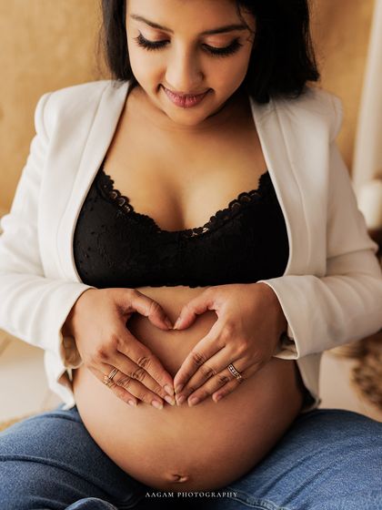 The heart hands, a simple and universal symbol of love for the little life growing inside. A beautiful, modern portrait.