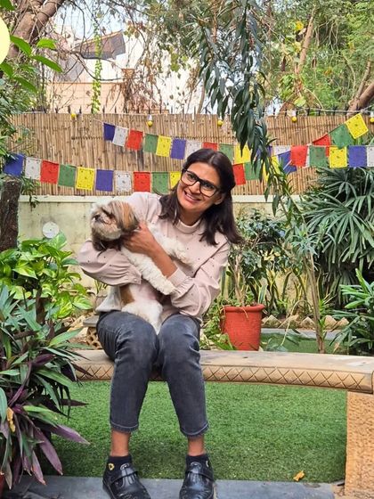 A happy smile from our founder Vizal and our regular guest, Choti the Shih Tzu. The prayer flags in the background add to the peaceful, positive vibe of our facility.