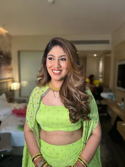 The layers and highlights in the hair are beautifully defined by these big, bouncy curls, creating a dynamic and photo-ready reception hairstyle.