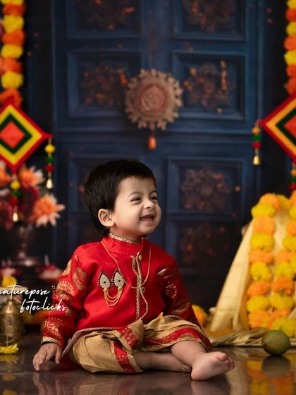 A joyful moment from our Ugadi shoot, with the child sitting amidst a colorful display of flowers and fruits.