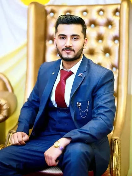 Seated like royalty, this groom's makeup enhances his smile and confidence. The look is perfect for a grand reception, ensuring he looks dashing in his formal portraits.