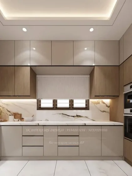 A U-shaped kitchen with integrated double ovens and a mix of beige and wood-tone cabinets. The marble-patterned countertop and backsplash add a touch of elegance.