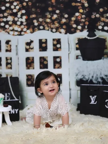 A little fashionista on the move! This toddler is captured crawling through a chic, shopping-themed set complete with designer bags and a mannequin.