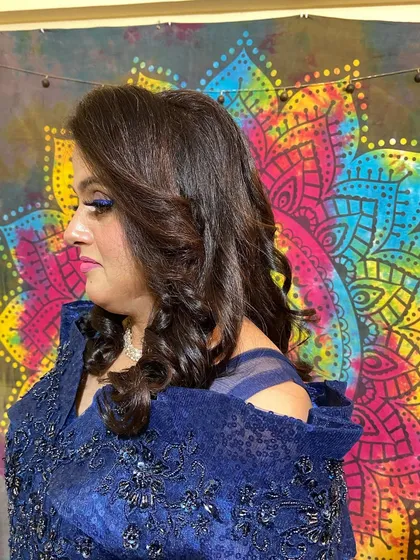 A side profile showing the soft curls and a bold blue eyeliner. A great example of how hair and makeup can work together to create a statement look.