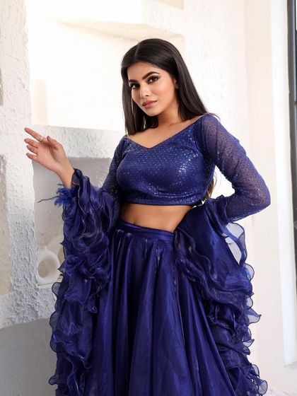 A beautiful portrait in the royal blue lehenga. The off-shoulder neckline and sparkling blouse frame the face beautifully.