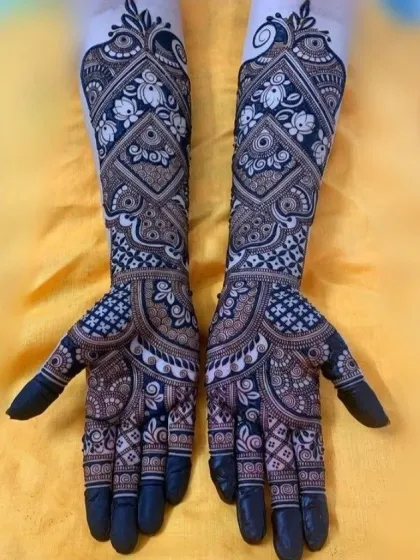 This design showcases beautiful negative space work, where the skin forms part of the pattern. The dark henna makes the floral motifs pop.