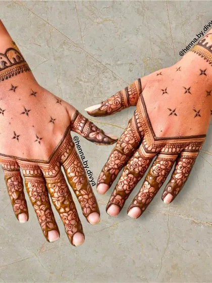 A sweet and simple design for a wedding guest. This pattern features floral work on the fingers and a V-shaped boundary on the back of the hand, with an elephant cuff for a touch of tradition.