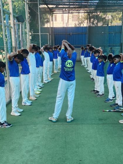 Discipline and preparation are key to success. Here, our players line up for stretching exercises in the nets, a crucial part of our training routine to ensure they are physically ready for practice.