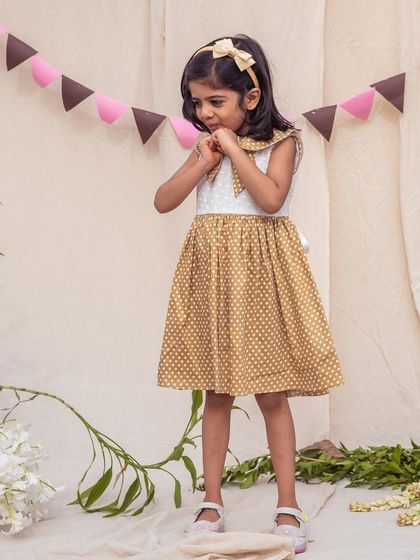 A shy smile in the mustard polka dot dress. The comfortable cotton fabric and classic A-line shape make it an easy choice for any day.