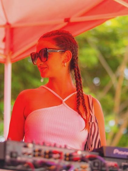 A DJ enjoying the vibe at our 'Colour Splash 2024' Holi party, set against the lush green backdrop of The Leela.