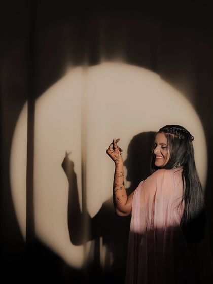 A playful and happy pose from a bride, showing off her personality and her beautiful mehandi.