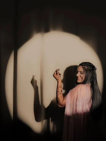 A playful and happy pose from a bride, showing off her personality and her beautiful mehandi.