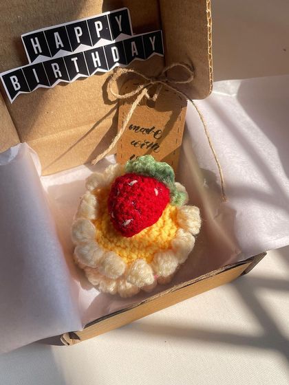 A forever mini crochet cake for a forever celebration. This strawberry cheesecake is zero-calorie, 100% adorable, and comes packed in a gift box with a "Happy Birthday" banner.