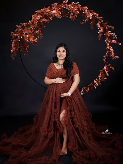 A beautiful solo portrait featuring a rust-colored gown and a matching floral hoop. The earthy tones and elegant pose create a warm and sophisticated look.