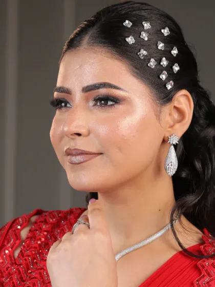 A detailed close-up of the makeup and hair for the red saree look. The sparkling hair accessories and glowing skin are the highlights here.