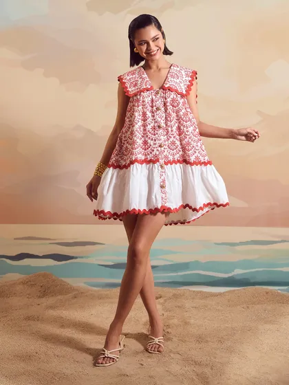 A joyful, smiling shot for Qala Clothing, featuring the Red Schiffli Sailor Dress in a dynamic pose.