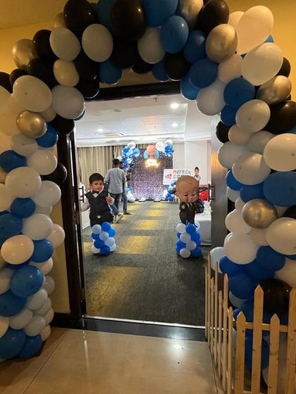 A grand entrance for a Boss Baby party, with a full balloon arch and character cutouts greeting guests.