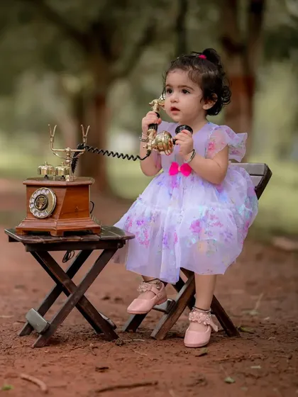 I love creating these whimsical scenes. Here, little Naira is having a very important conversation on a vintage rotary phone during her themed portrait session. It is these playful, imaginative moments that make for unforgettable baby photography.