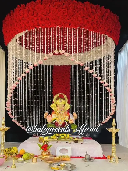 This is a complete Ganpati decoration set, available for purchase and perfect for home celebrations. The design features a beautiful floral canopy of artificial red and white flowers, offering a reusable and eco-friendly option for your gharguti Ganpati.