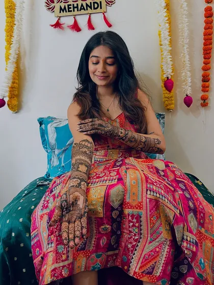 A close-up of Shrutika's hand, showing the intricate details of her bridal mehendi.