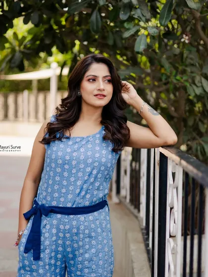 A classic three-quarter portrait taken outdoors. The actress leans against a railing with a thoughtful expression, showcasing a different mood for her portfolio.