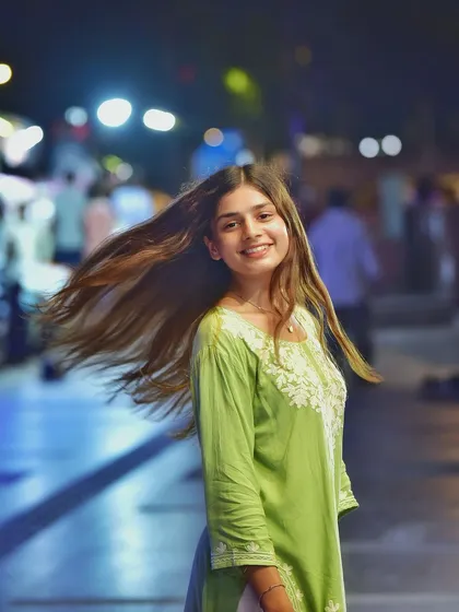 A fun, dynamic shot with her hair caught in motion. This adds a sense of energy and spontaneity to the night portrait, making it feel alive.