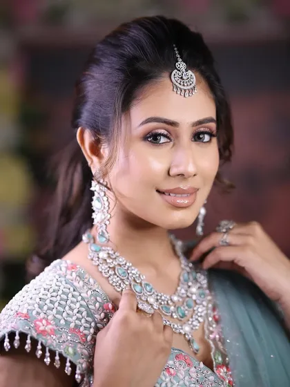A smiling bride-to-be wearing a beautiful layered zircon necklace with pastel blue stones. This set is perfect for a pre-wedding shoot or a modern wedding ceremony.