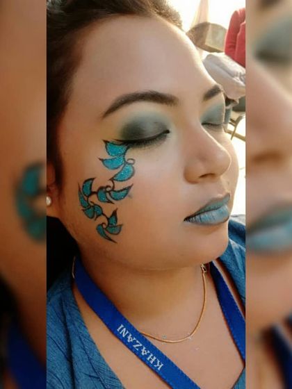 With eyes closed, you can see the full effect of the blended blue and green eyeshadow. This is a great example of the artistic skills our students develop.
