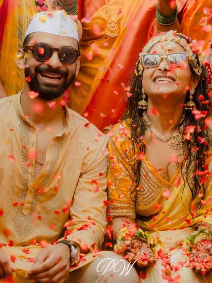 A candid shot of the couple showered in petals during their Haldi. Their smiles and sunglasses perfectly capture the cool, happy vibe of the day.