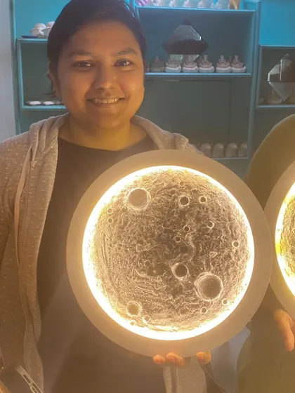 A participant holds up her finished moon lamp, a perfect circle of light and texture. It's amazing to see what can be created in just one session.