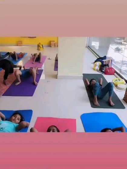 Children practicing Setu Bandhasana (Bridge Pose), a foundational backbend that strengthens the back, opens the chest, and calms the mind. Our instructors ensure a safe and encouraging space for all levels.