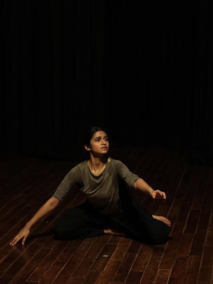 A dancer in a seated pose during a tech run.