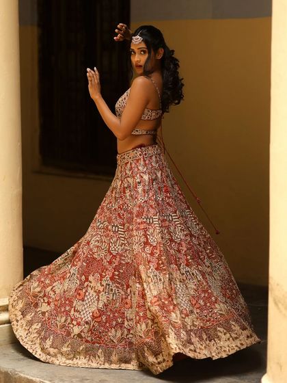 A full-length shot of Poornima Ravi in a beautiful printed lehenga. The hairstyle I created is a modern take on a traditional look, perfect for this fusion outfit.