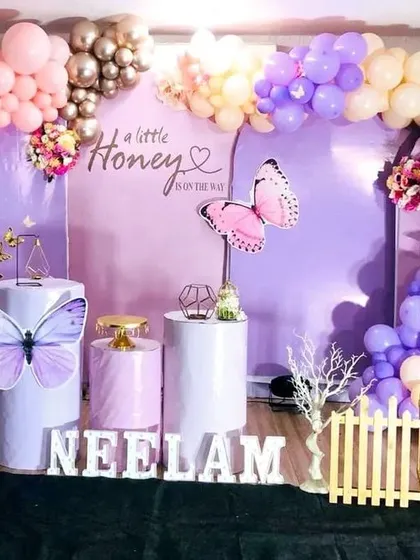 For a modern take on a baby shower, I designed this butterfly theme. The setup includes a custom backdrop, a multi-colored balloon arch, and themed props like the butterfly cutouts and pedestal stands.