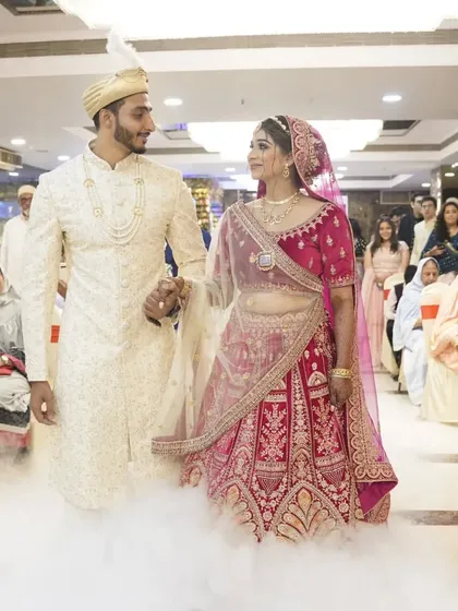 The couple makes their entrance through a cloud of smoke, a cinematic moment from their wedding reception.