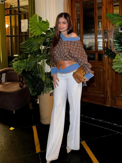 A high-fashion look featuring a designer-inspired top and white wide-leg pants.