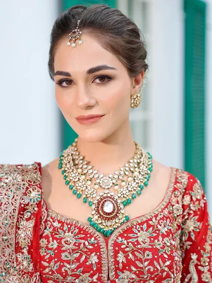 A direct, confident gaze. The makeup enhances her beautiful features, with a focus on flawless skin and perfectly defined brows.