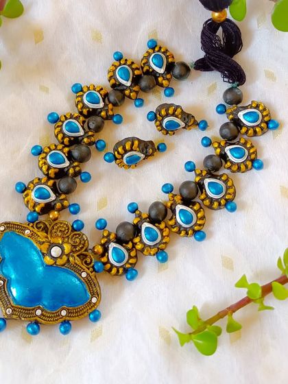 The butterfly-pendant necklace in a blue and gold combination.