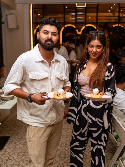A happy couple holds up their desserts, enjoying the sweet end to a perfect brunch.
