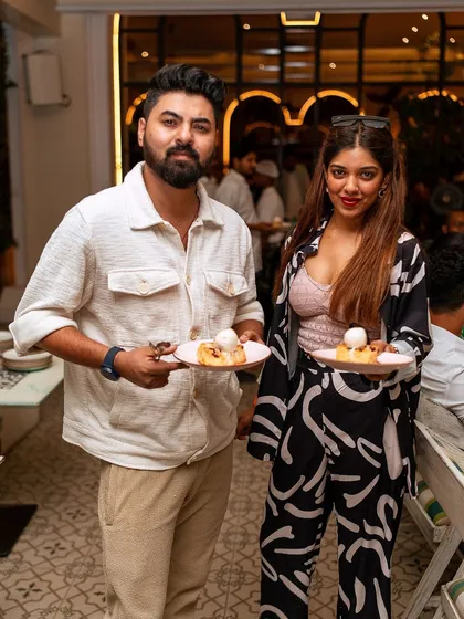 A happy couple holds up their desserts, enjoying the sweet end to a perfect brunch.