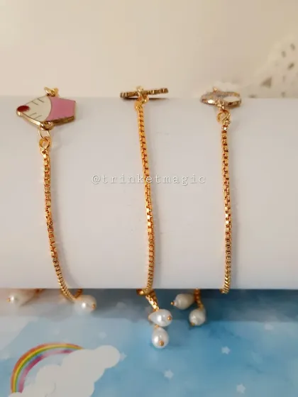 A close-up of the pearl details on the adjustable kids' charm bracelets. Each charm is paired with a tiny pearl for an extra touch of elegance.