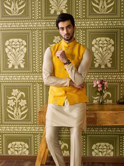 Brighten up the Haldi ceremony with this vibrant yellow waistcoat. I've detailed it with subtle hand-embroidery and paired it with a simple beige kurta pyjama, creating a look that is festive, comfortable, and effortlessly stylish.
