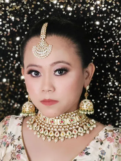 A beautiful Navratan-style choker with multi-colored stones and a matching maang tikka. This is a vibrant choice for pre-wedding festivities.