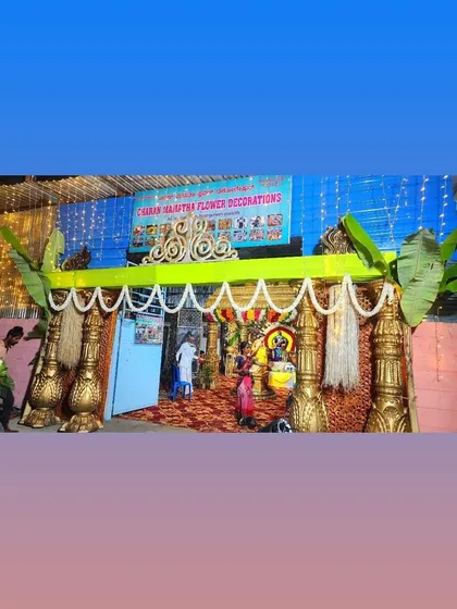 An entrance decoration for a local event, featuring traditional pillars and banana plants.