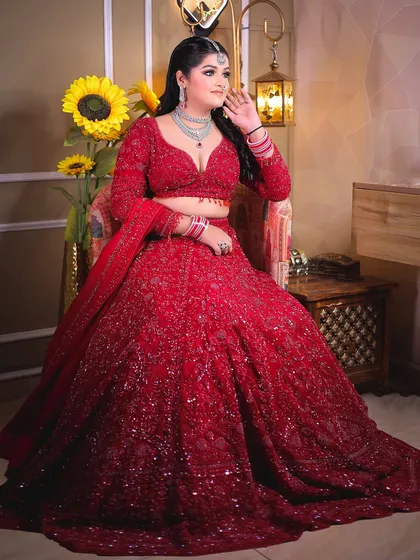 A seated portrait that allows the heavily embellished lehenga to be displayed beautifully.