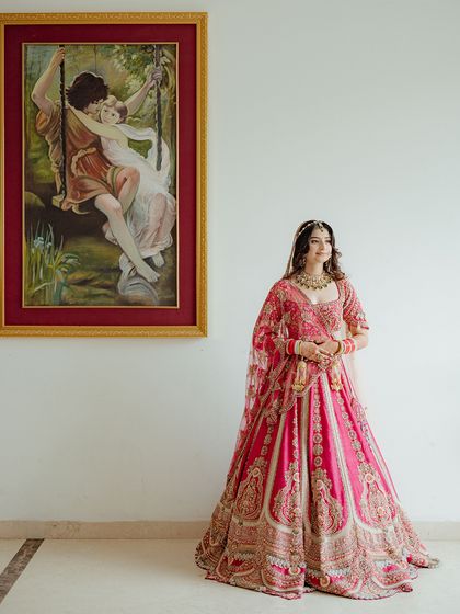 The bride stands beside a romantic painting, creating a beautiful parallel between art and life on her wedding day.