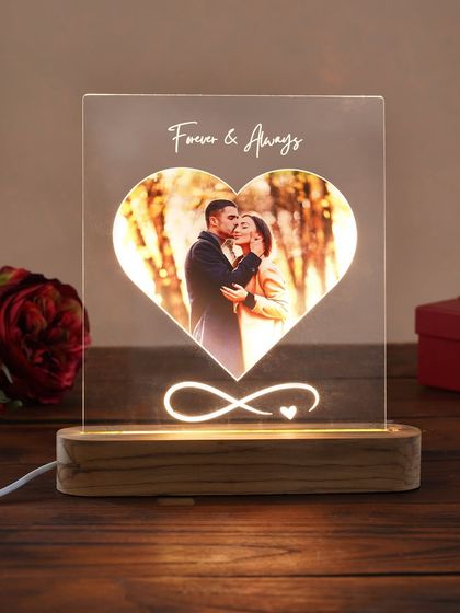The heart-shaped LED lamp, illuminated to showcase the couple's photo within the glowing heart. It's a beautiful symbol of love.