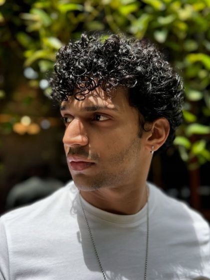 Curls for the win. This client's short, tight curls are perfectly defined and shaped for a stylish, effortless look that's easy to maintain.