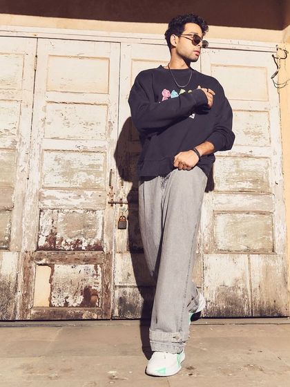 A full-length shot against a rustic backdrop for the HT Brunch editorial. This angle shows how the oversized silhouette of the pants and sweatshirt creates a confident, contemporary look for Siddhant Chaturvedi.