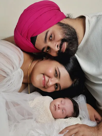 A beautiful and intimate family portrait with a newborn. The overhead angle creates a unique perspective, drawing focus to the loving expressions of the new parents.